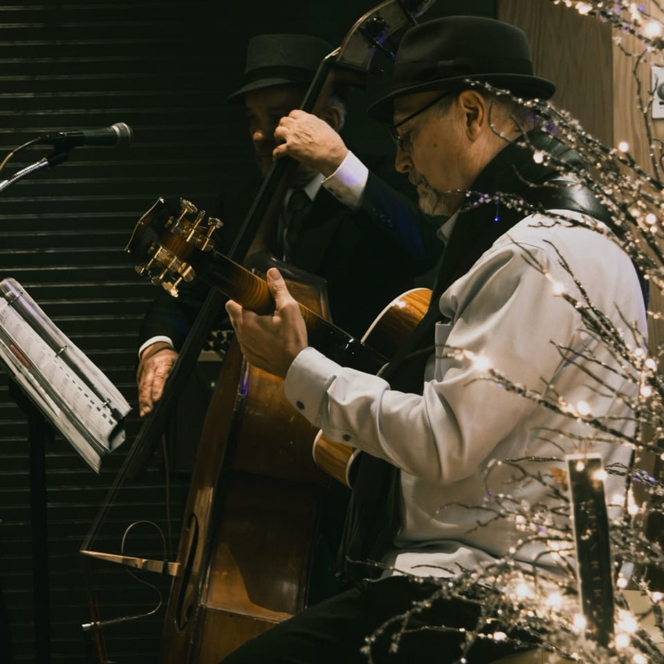 Two musicians, one playing an upright bass and the other a guitar, performing jazz music.